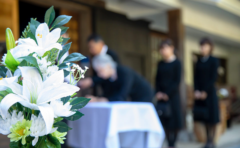 葬儀撮影サービス｜燈が式場で遺族を配慮しながら葬儀撮影する白百合のアレンジメント